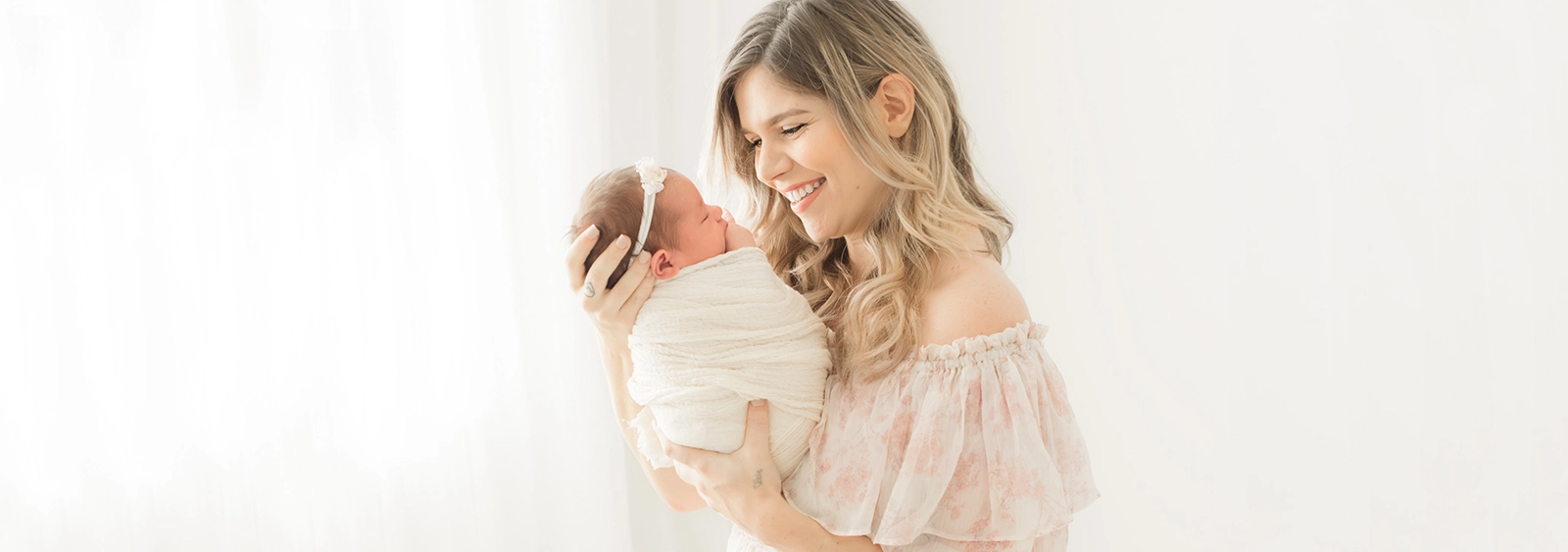 Newborn baby wrapped in neutral blanket during in-home session in Sarasota